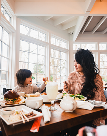 A group of people dining in the picturesque Cafe and The Frick in Pittsburgh, PA.