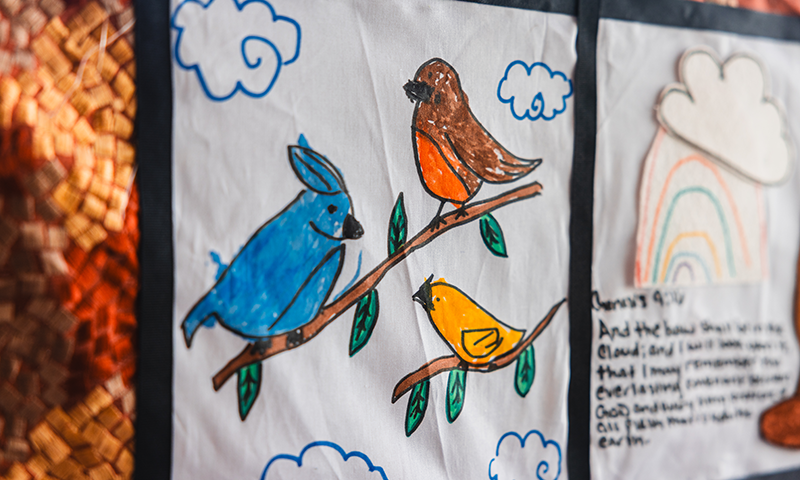 a quilt patch that shows three birds sitting on a branch