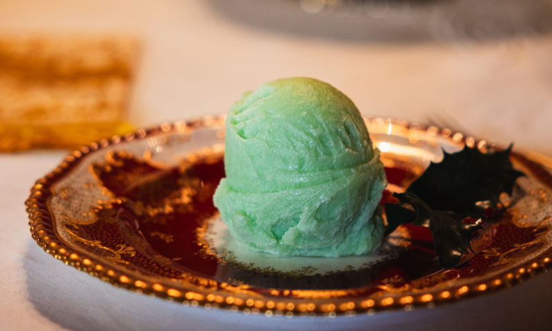 a faux scoop of pistachio ice cream sits on a plate